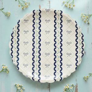 Elegant blue bow and floral scalloped party plates on tablescape.