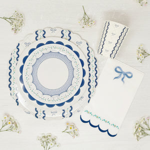 Floral and bow detail on blue scalloped paper napkins for baby showers and baptisms