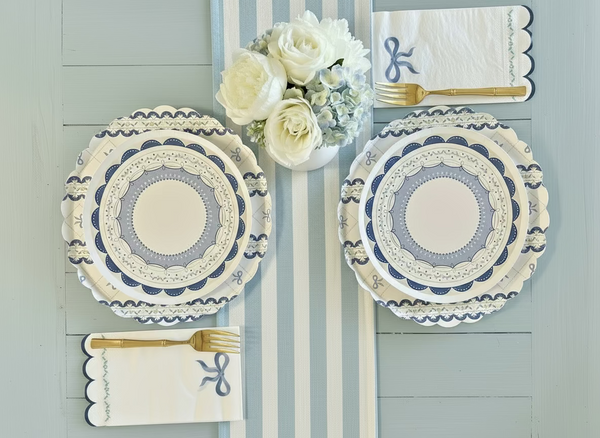 Decorative plates with floral arrangement and cutlery on a striped background