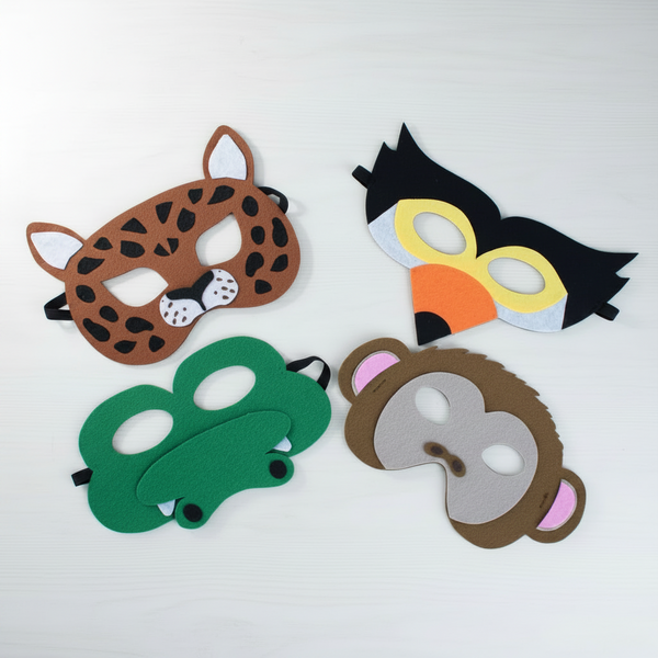 Four colorful felt animal masks laid out on a white background: a brown spotted cat mask, a black-and-yellow bird mask, a green alligator mask, and a brown monkey mask with pink ears.